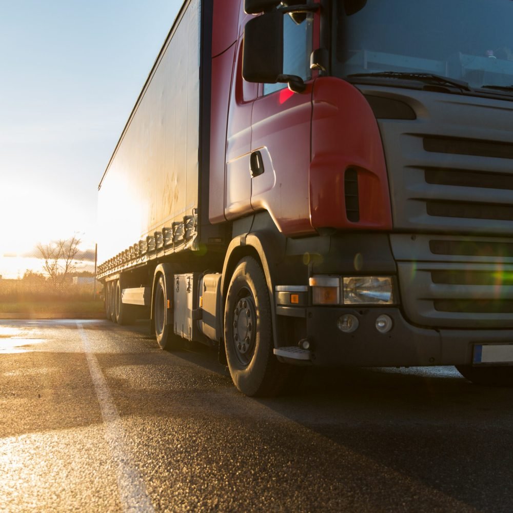 transportation, freight transport and vehicle concept - close up of truck on parking